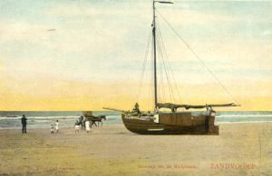Een boot op het strand van Zandvoort met spelende kinderen erbij.